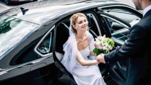 Bride and groom stepping out of a limousine at a Houston wedding venue.